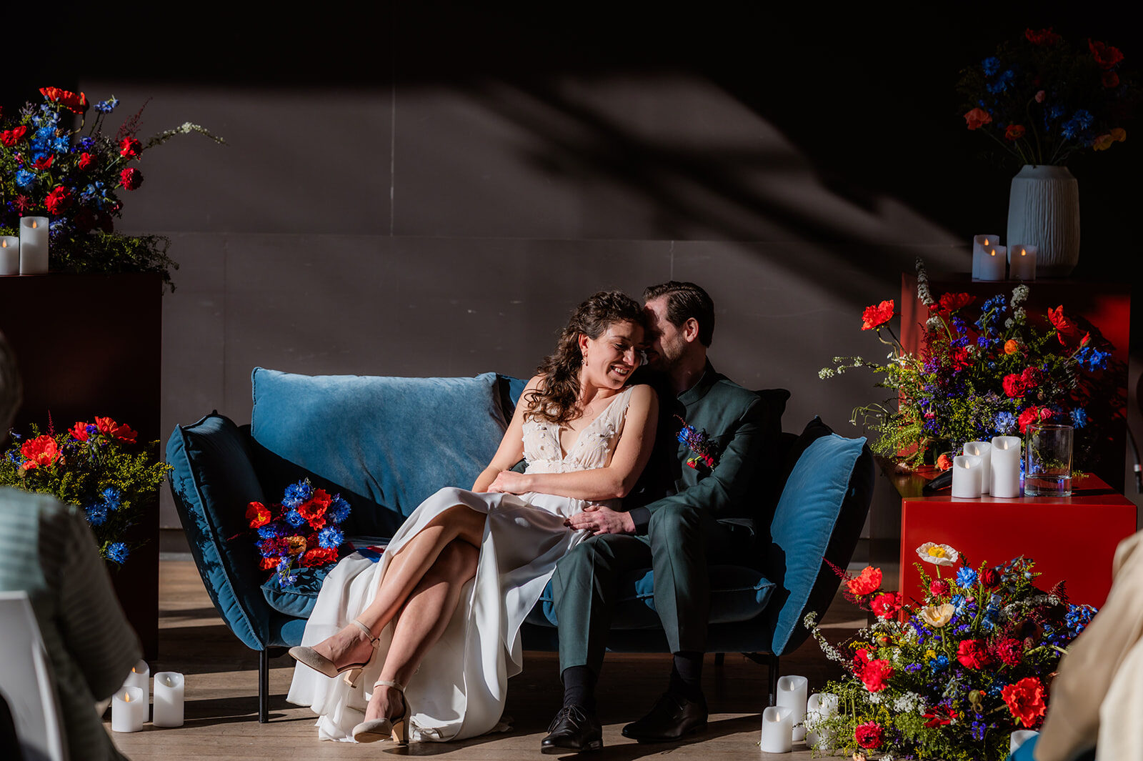 Daisy — bruidspaar op blauwe sofa met kleurrijke bloemendecor