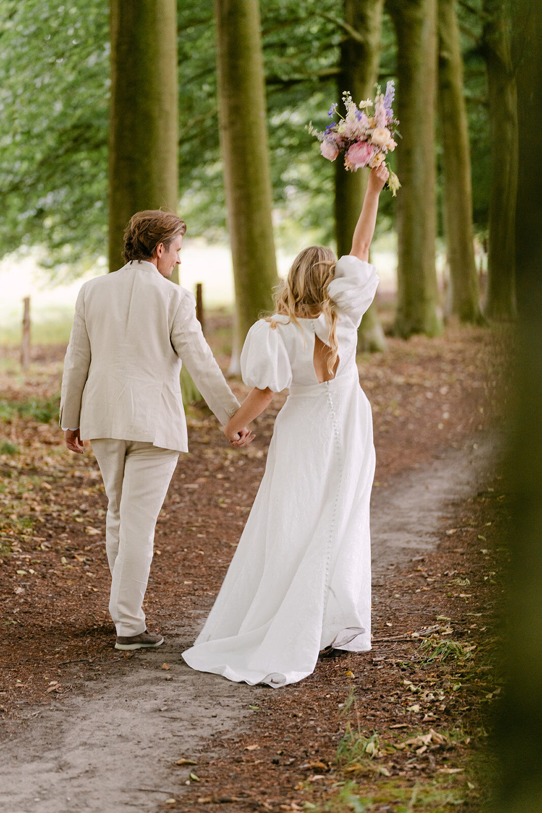 Evelien & Olivier — bruidspaar in de dreef met kleurrijk veldboeket