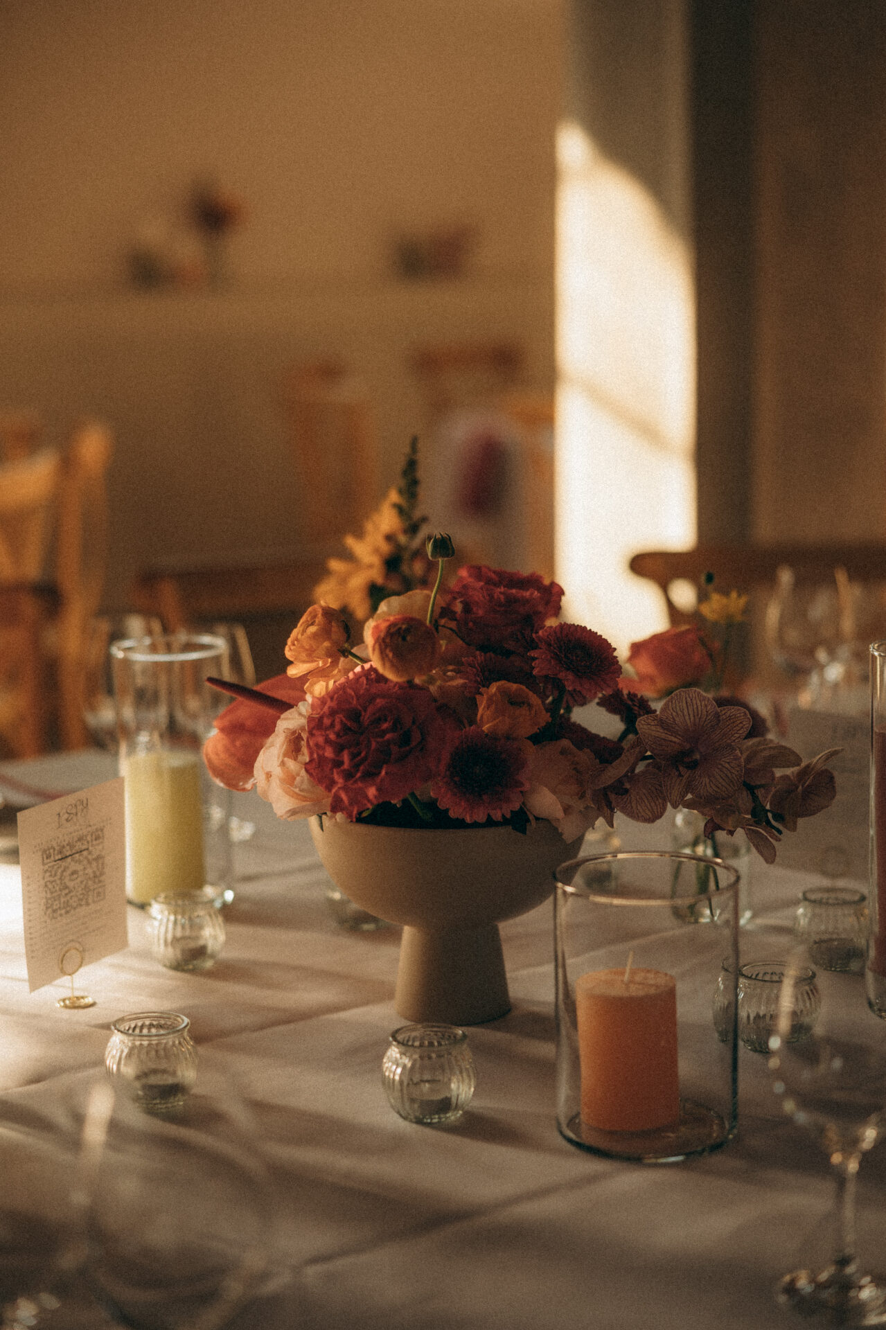 Fabiola — centerpiece met warme bloemen in zacht avondlicht